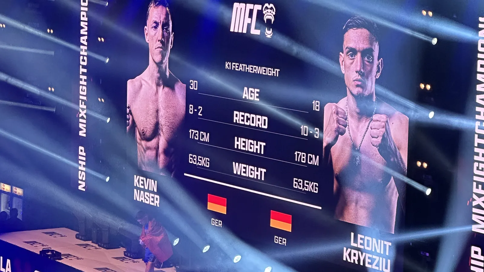 Riesige LED-Leinwand bei der Mix Fight Championship zeigt die Kampfvorstellung Kevin Naser gegen Leonit Kryeziu mit Alter, Bilanz, Größe und Gewicht; darunter die Bühne mit MFC-Schriftzug